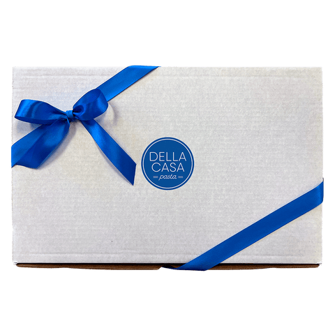 Image of a white box with a blue logo in the center wrapped with a blue ribbon