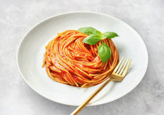 Plate of spaghetti with tomato sauce on a white plate